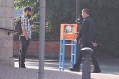 two men walking down the street talking to each other