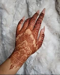 a woman's hand with henna tattoos on it