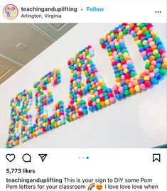 the word dad spelled out with colorful beads on top of a white wall in an office