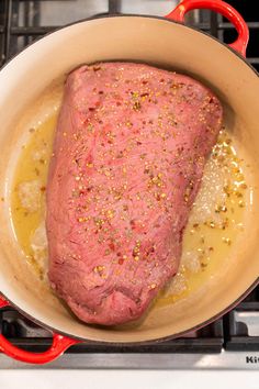 raw meat cooking in a pan on the stove top with mustard and seasoning around it