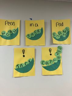 four pieces of paper with words written in green and yellow on them hanging from the wall