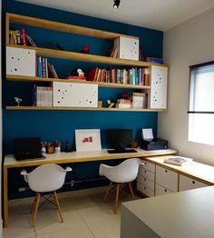 an office with blue walls and white desks, bookshelves on the wall