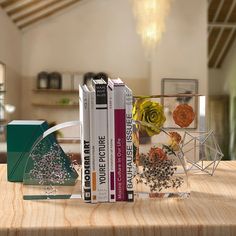 three books are stacked on top of each other in front of a vase with flowers