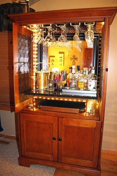 an old fashioned liquor cabinet with lights on it