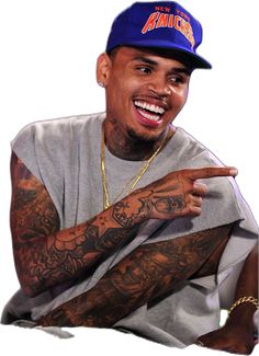 a man with tattoos on his arms pointing to the side and smiling at the camera