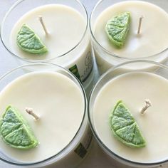 four candles with green leaf decorations on them