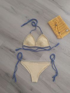 two bikinis on the floor next to a crochet bag and knitting kit