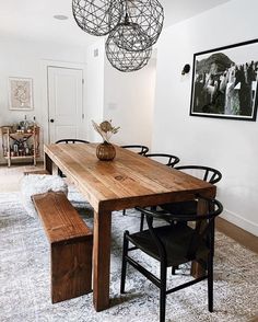 a dining room table with chairs and a bench