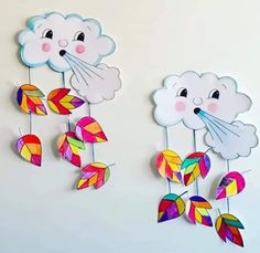 two wind chimes made out of paper with clouds and leaves hanging from the sides