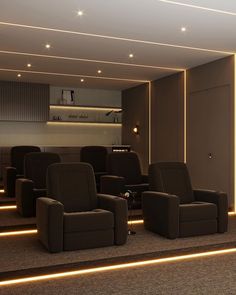 an empty theater with brown chairs and lights on the walls, in front of a tv