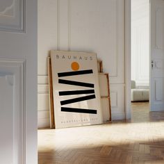 an art piece sitting on top of a hard wood floor next to a white wall