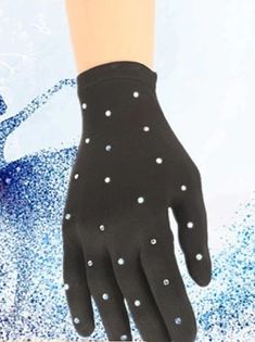 a pair of black gloves with white polka dots on the wrist and palm, in front of a blue background