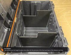 the inside of a black plastic container with orange trimmings and two separate compartments