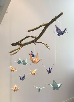 several origami cranes hanging from a tree branch