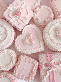 pink and white decorated heart shaped cookies in a box with bows on the top,