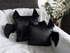 four black velvet pillows on a white bed