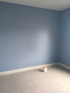 an empty room with blue walls and carpet