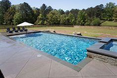 an empty swimming pool with lounge chairs around it