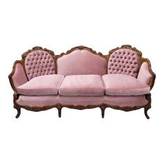 a pink couch sitting on top of a wooden frame