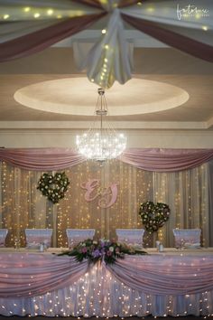 a wedding reception setup with chandelier and flowers