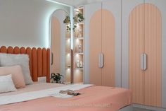 an orange and white bedroom with mirrored closets on the wall, bedding and pillows