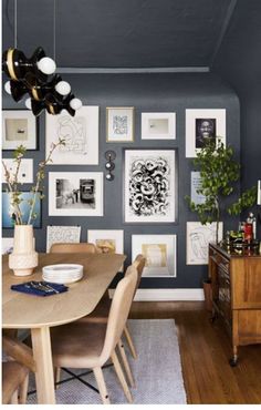 a dining room with blue walls and pictures on the wall