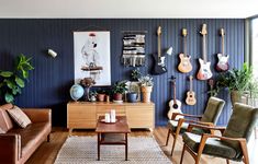 a living room filled with furniture and guitars on the wall