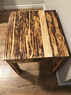 a table made out of wood sitting on top of a hard wood floor next to a door