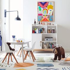 a child's playroom with toys, bookshelves and artwork on the walls