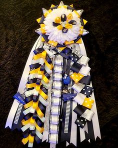 a close up of a bunch of ribbons on a black surface with white and yellow decorations