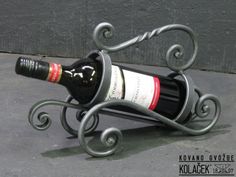 a wine bottle holder made out of wrought iron