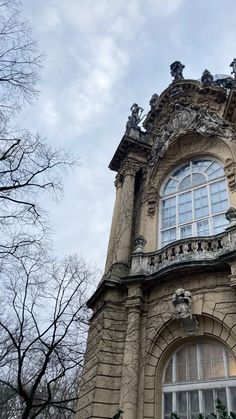 an old building with many windows and statues on it