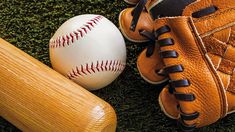 a baseball bat, glove and ball sitting on the ground next to it's mitt