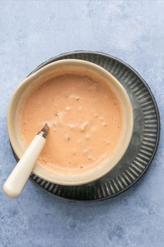 a bowl of soup with a spoon in it on a blue tablecloth, top view