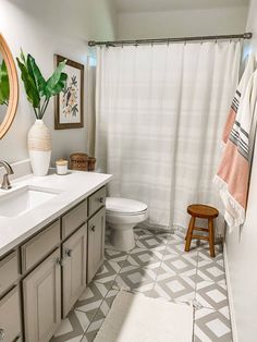 a bathroom with a toilet, sink, and shower curtain is shown in this image