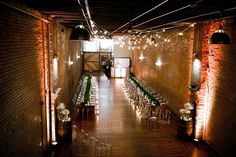 an empty room with tables and chairs set up for a wedding reception at the end of the hall