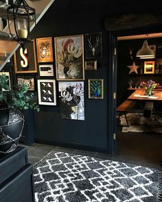 a living room with pictures on the wall and a black rug in front of it