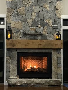 a stone fireplace with two lit candles in it