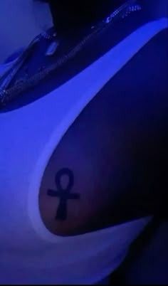 an egyptian symbol tattoo on the back of a woman's shoulder