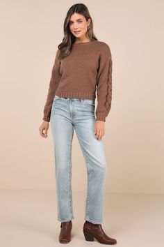 a woman wearing a brown sweater and jeans