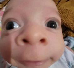 a close up of a baby with big eyes