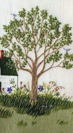 this is an embroidered picture of a house and tree in the grass with birds flying around it