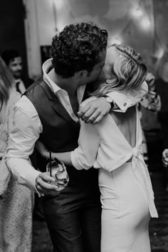 a man and woman kissing each other while standing next to each other on a dance floor