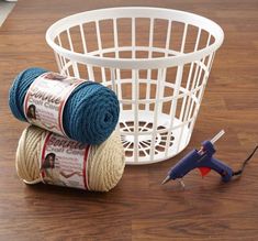 two skeins of yarn next to a spool of thread on a table