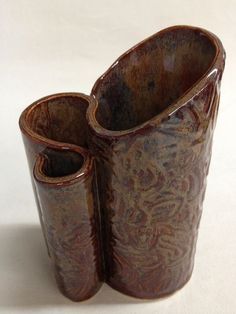 two brown vases sitting on top of each other