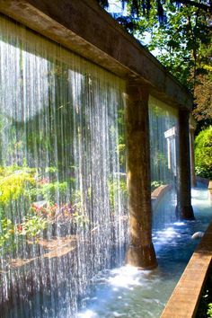 the water is running down the side of the building and it's walls are covered with sheer curtains