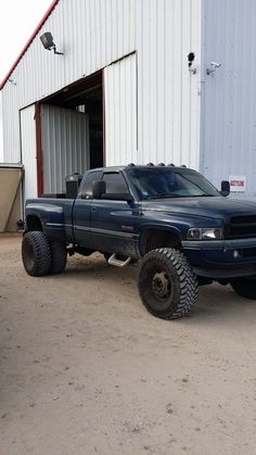 a large truck parked in front of a building with two tires on it's flatbed