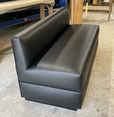 a black leather couch sitting on top of a hard wood floor