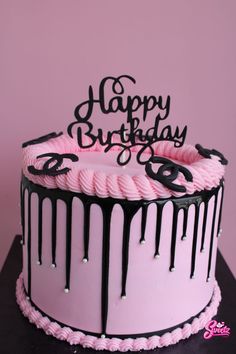 a pink and black birthday cake with dripping icing