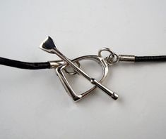 Dramatic Large Sterling Silver Stirrup Necklace on long Leather Cord. This is a beautiful statement piece to add to your Equestrian Jewelry collection. The toggle clasp has another Sterling Silver Stirrup as well as a Crop. The Large Stirrup Pendant measures 2" tall by 1-1/2" wide across the footbed. The Leather Cord measures 24" in length. The necklace closes with a toggle clasp stirrup that is 5/8" tall by 1/2" wide, and the crop measures 1-1/4" in length. Each Stirrup Necklace is handcrafted, Equestrian Jewelry, Stirrups, Toggle Clasp, Leather Cord, Equestrian, Statement Pieces, Jewelry Collection, Personalized Items, Sterling Silver